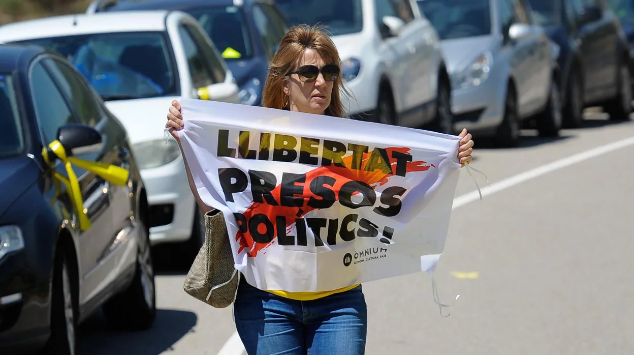 Una mujercon una parcarta a favor de la libertad de los soberanistas presos, en la prisión de Lledoners, en julio
