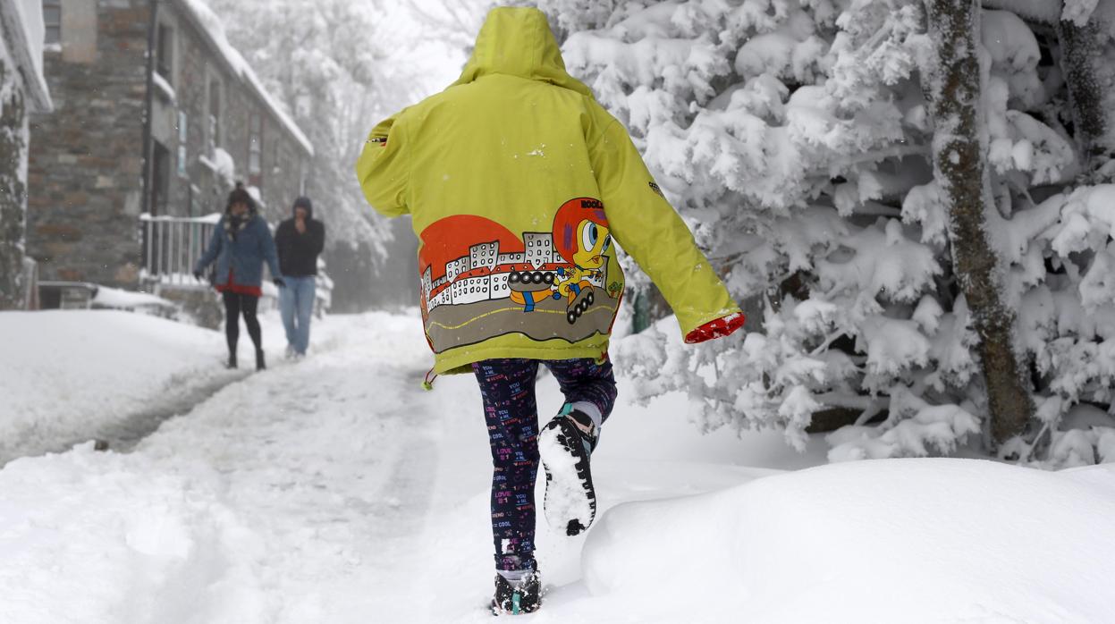 Una niña caminando sobre la nieve en O Cebreiro el domingo