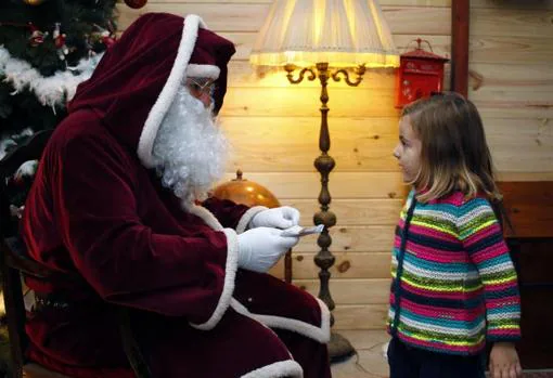 Papá Noel con una niña en su casa alicantina