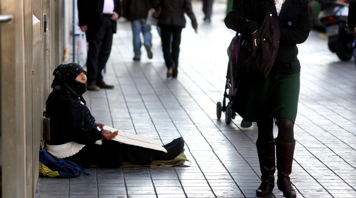 Una mujer pide limosna en las calles de Valencia