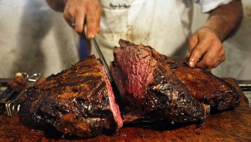 Un asador corta un trozo de carne bovina