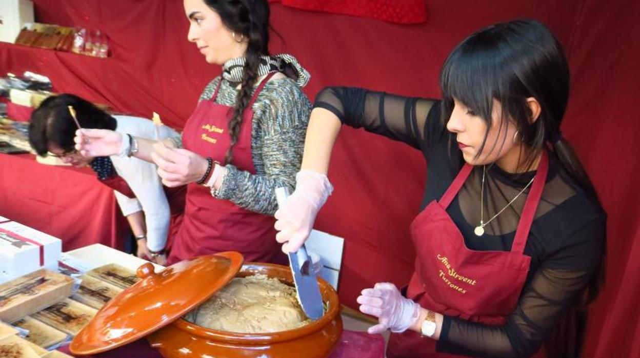 Elaboradores de turrón artesano muestran sus creaciones en un puesto de la feria