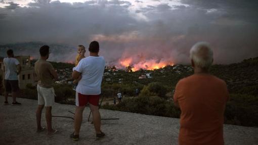 Personas viendo el incendio desde Rafina, ciudad cercana a Atenas