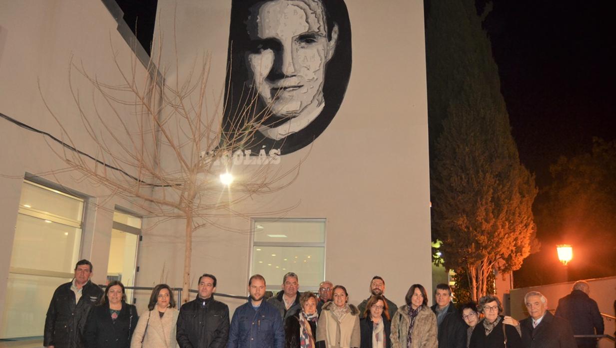 Familiares y concejales posan ante un mural de Juan Martín de Nicolás en el exterior de la biblioteca, realizado por Franz Campoy