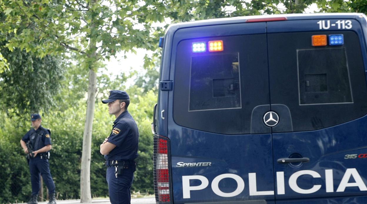 Dos agentes de la Policía Nacional patrullan junto a su vehículo