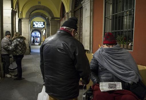 Eduardo, de espaldas, con un compatriota en los sopoertales de la Plaza Mayor