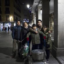 Voluntarios reparten comida a los mendigos de la Plaza Mayor