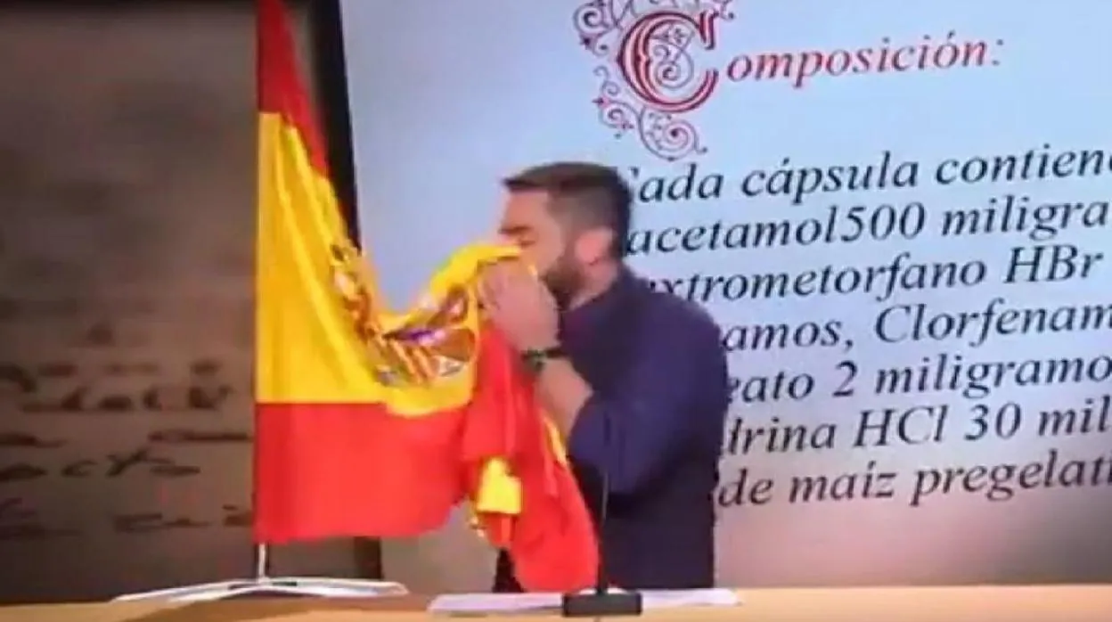 El cómico Dani Mateo, sonándose los mocos en la bandera de España