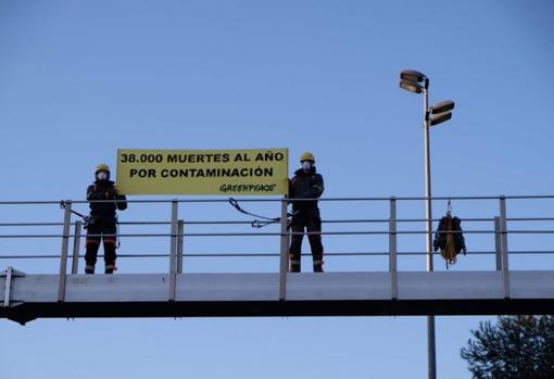 Dos activistas de Greenpeace sostienen una pancarta contra la contaminación