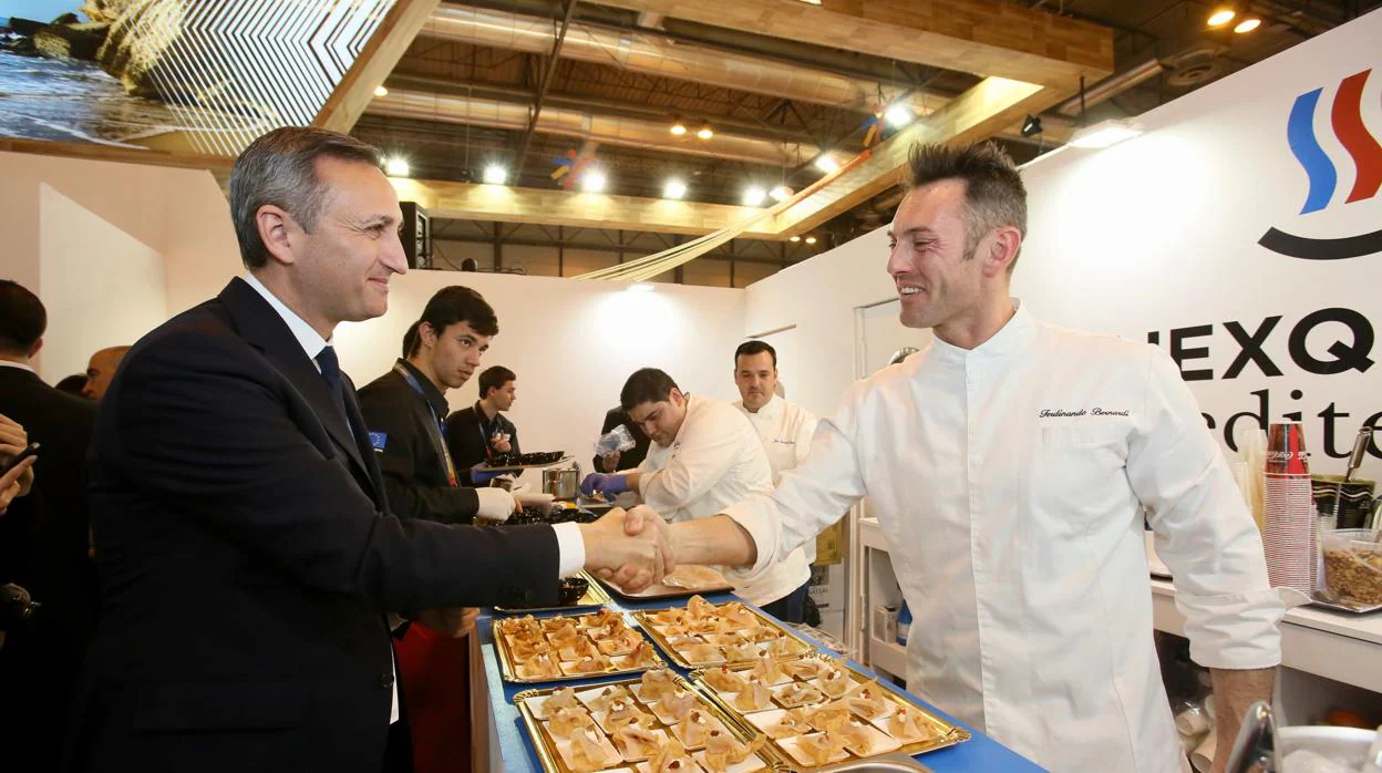 César Sánchez saluda a un cocinero en la feria de turismo de Madrid