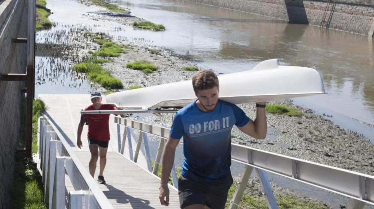 Los deportistas levantan un remo desde el río sin casi caudal