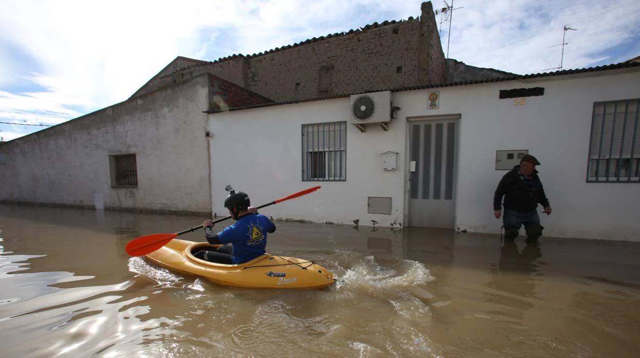 Un lugareño, desplazándose en piragüa por una calle de Novillas durante una crecida del Ebro