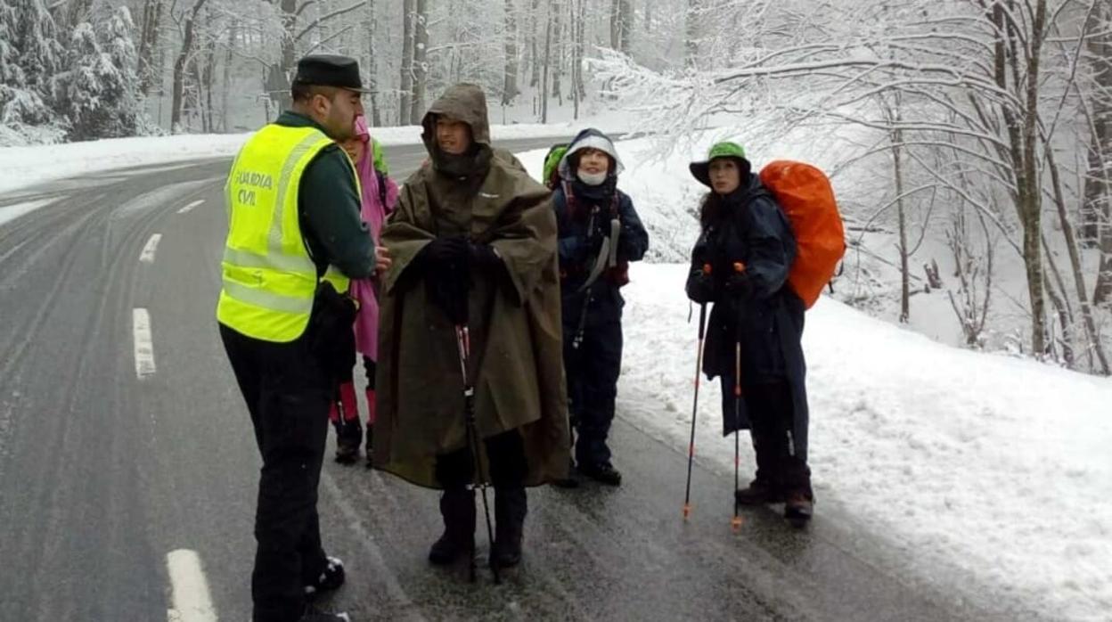 Un agente de la Guardia Civil acompaña esta mañana a unos peregrinos en Ibañeta