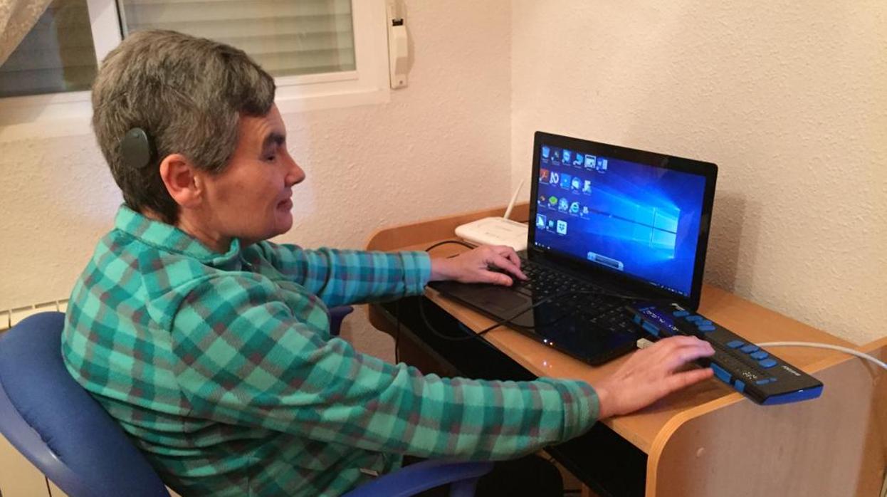 María Jesús Cañamares, escritora sordociega, sentada delante de su ordenador