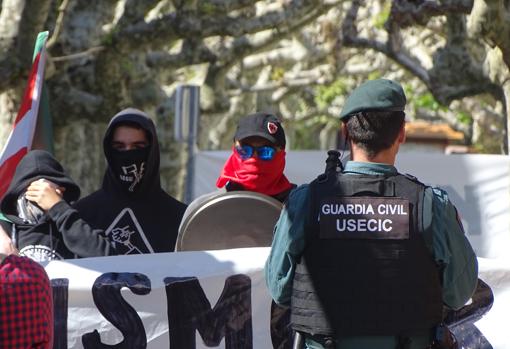 Encapuchados frente a un agente de la Guardia Civil