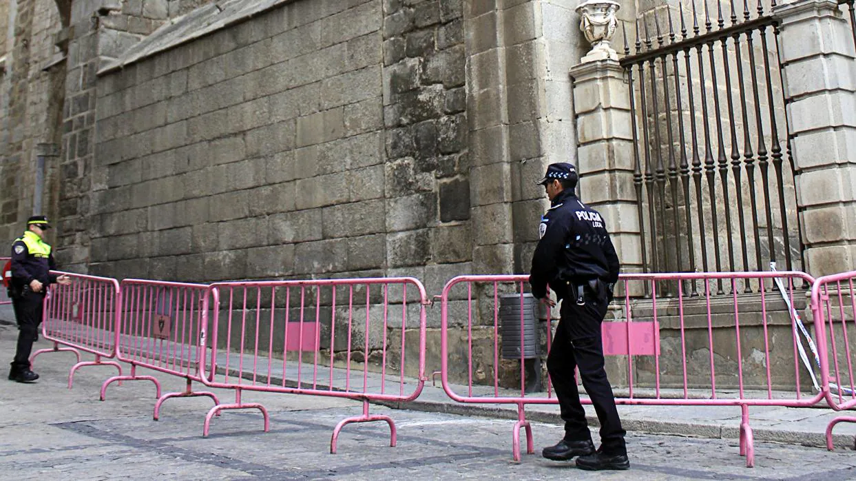 Dos policías locales de Toledo colocan vallas al lado de la torre, tras la caída de la piedra en octubre