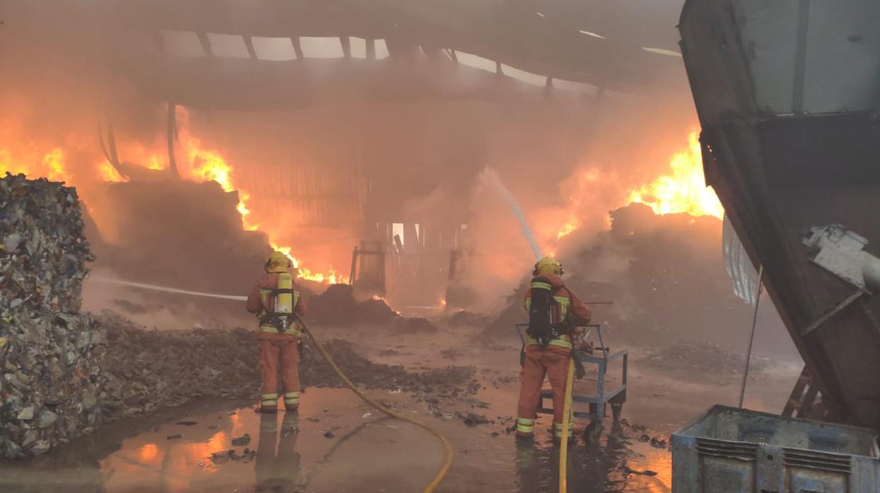 Efectivos de bomberos trabajan en la extinción del incendio en la plata de reciclaje