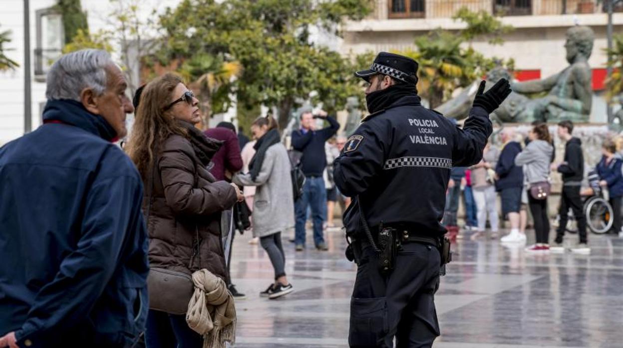 Un policía conversa con una mujer en una calle de Valencia en una imagen de archivo