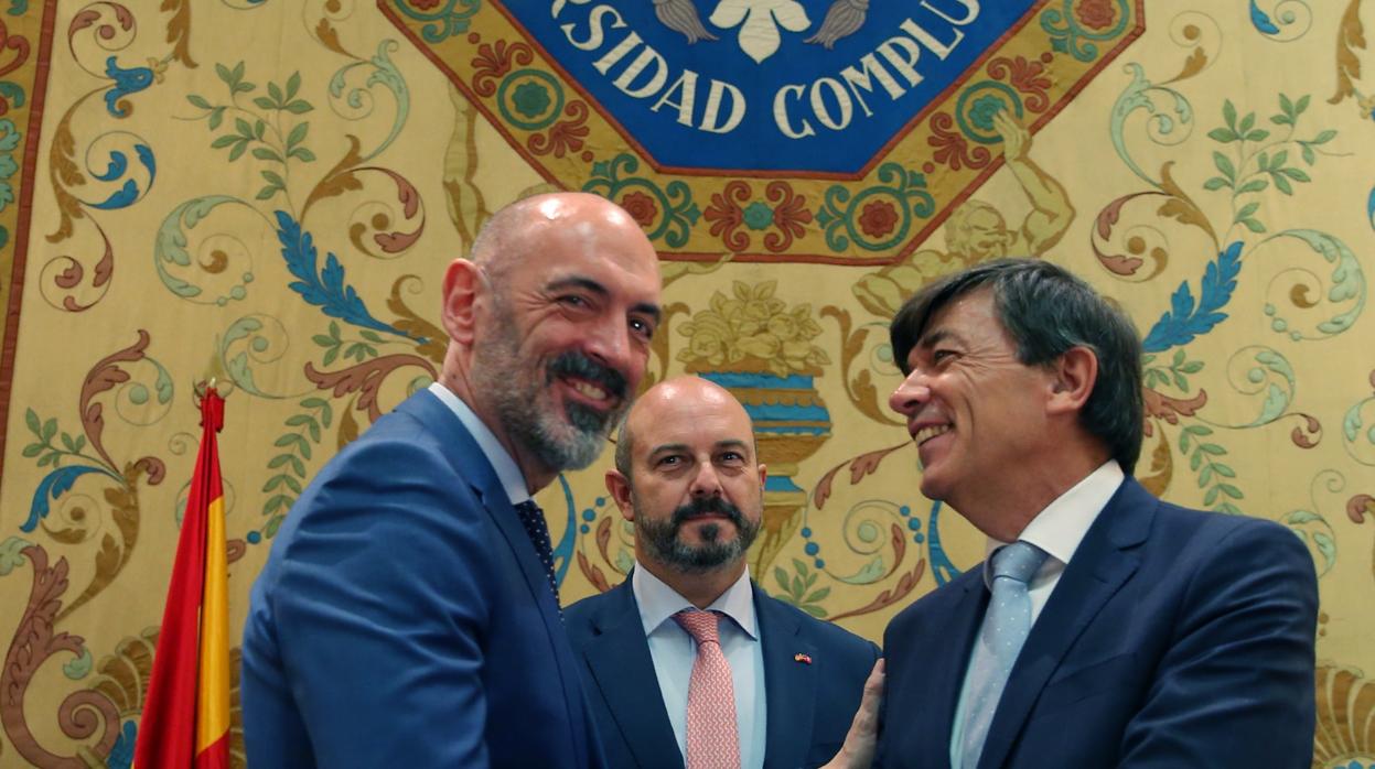 Joaquín Goyache (izq.), rector de la Universidad Complutense, saluda al rector saliente, Carlos Andradas. Detrás, el presidente en funciones Pedro Rollán