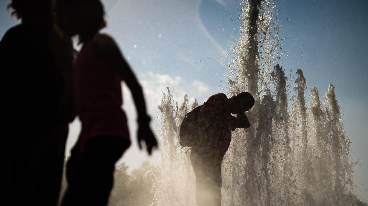 Varias personas se refrescan en una fuente para sofocar la ola de calor