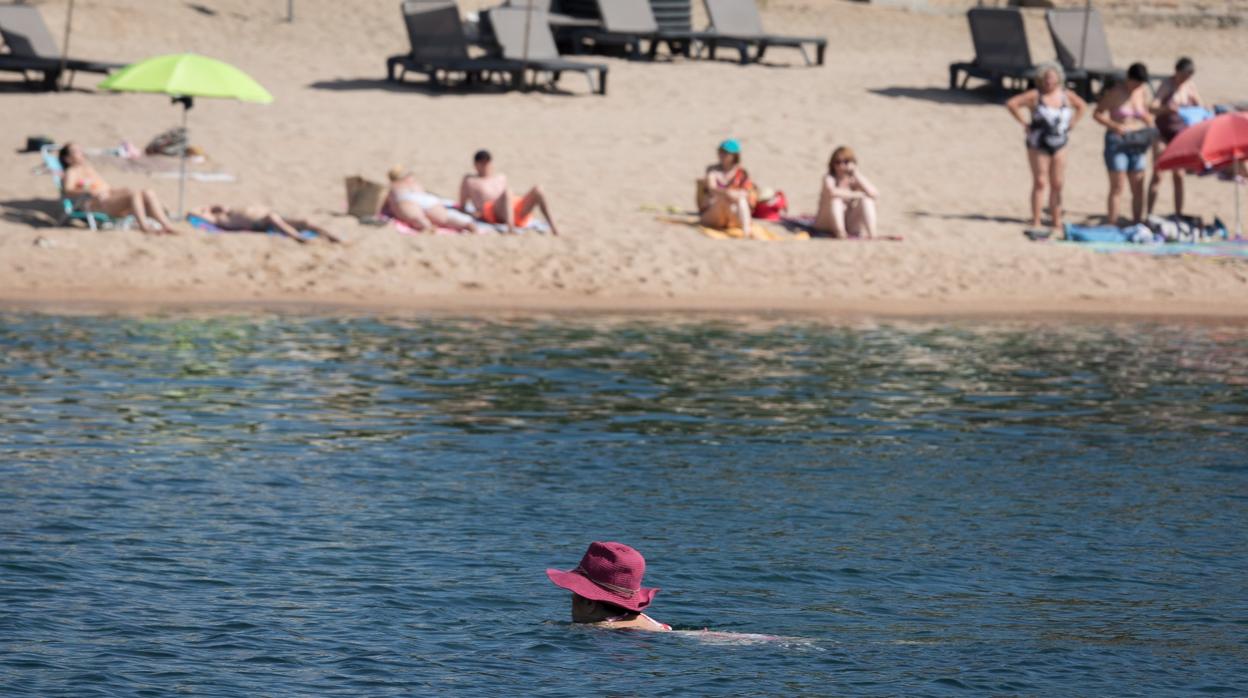 Varios bañistas se refrescan en la playa de Sant Feliu de Guixols, en Gerona