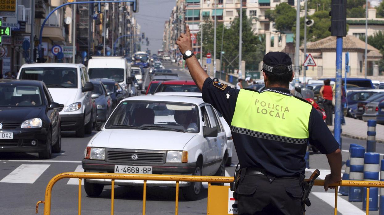 Imagen de un policía local dando indicaciones en Alicante