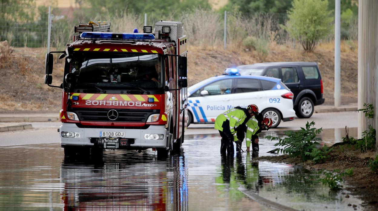 Los bomberos trabajan limpiando una zona de la VA-30 inundada por las fuertes lluvias