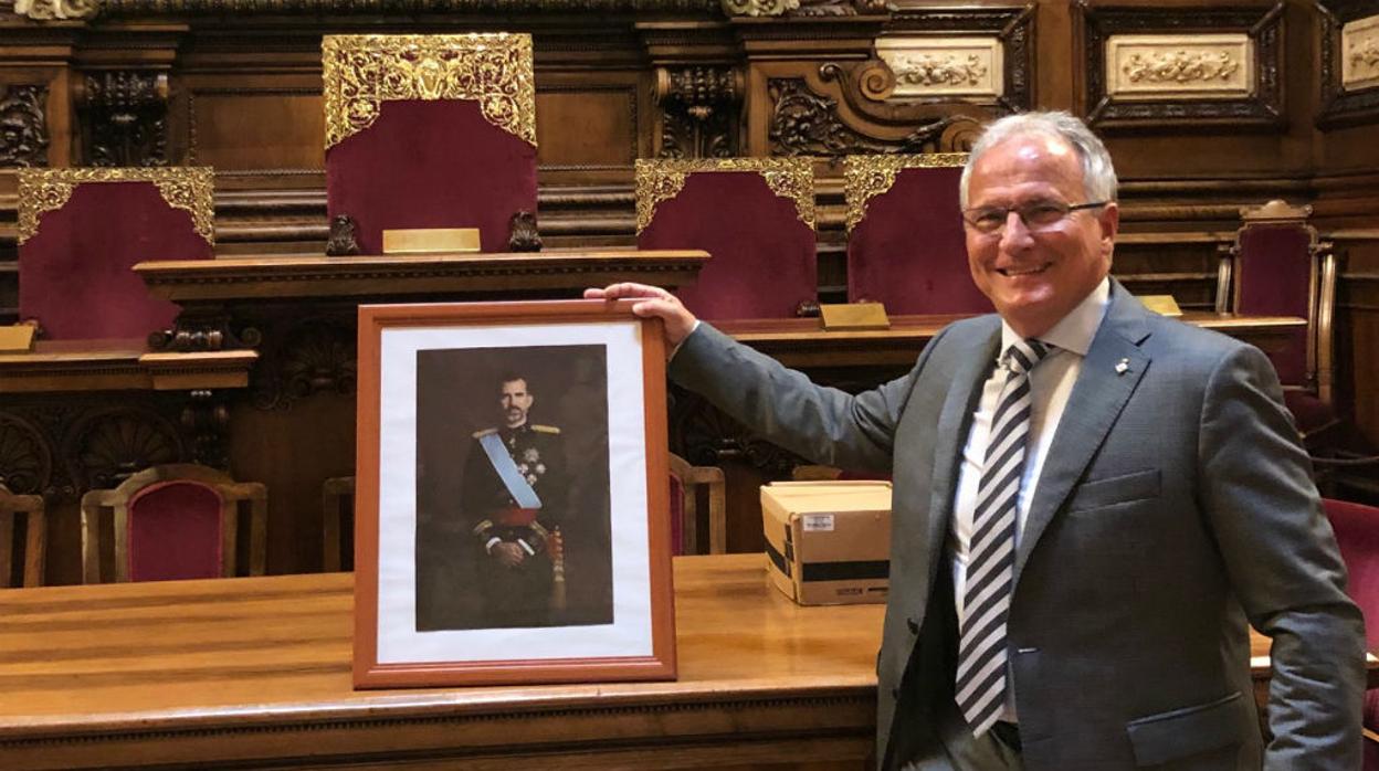 Imagen del presidente del Grupo Municipal del PP en Barcelona, Josep Bou, agarrando el retrato del Rey Don Felipe