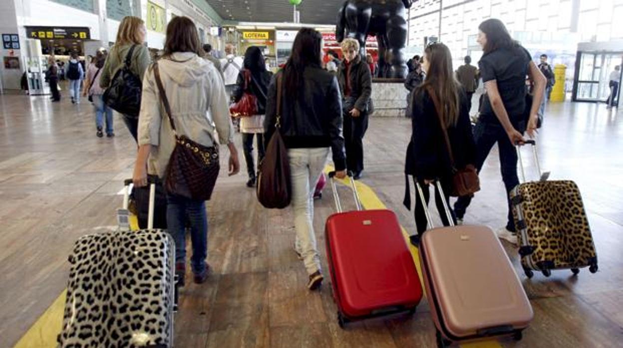 Un grupo de jóvenes en el aeropuerto se marchan con sus maletas