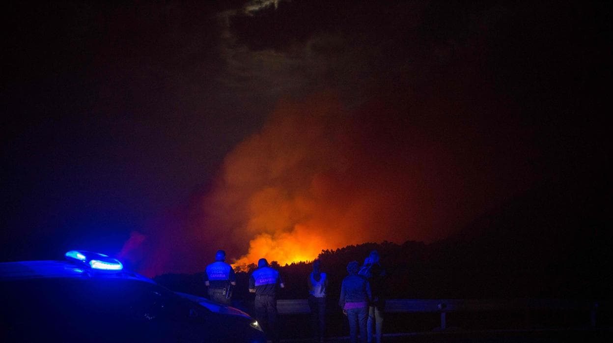 Policías y ciudadanos observan el fuego del incendio de Gran Canaria en Valleseco