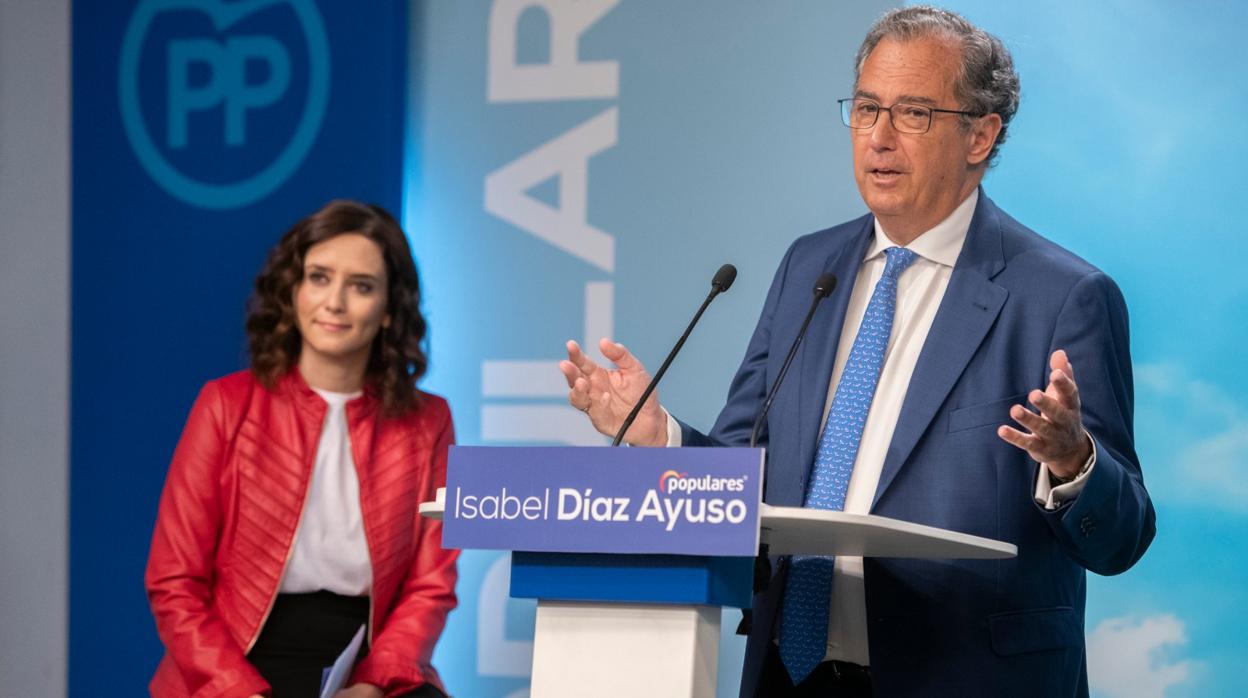 Enrique Ossorio interviene durante un acto, con Isabel Díaz Ayuso observando en segundo plano