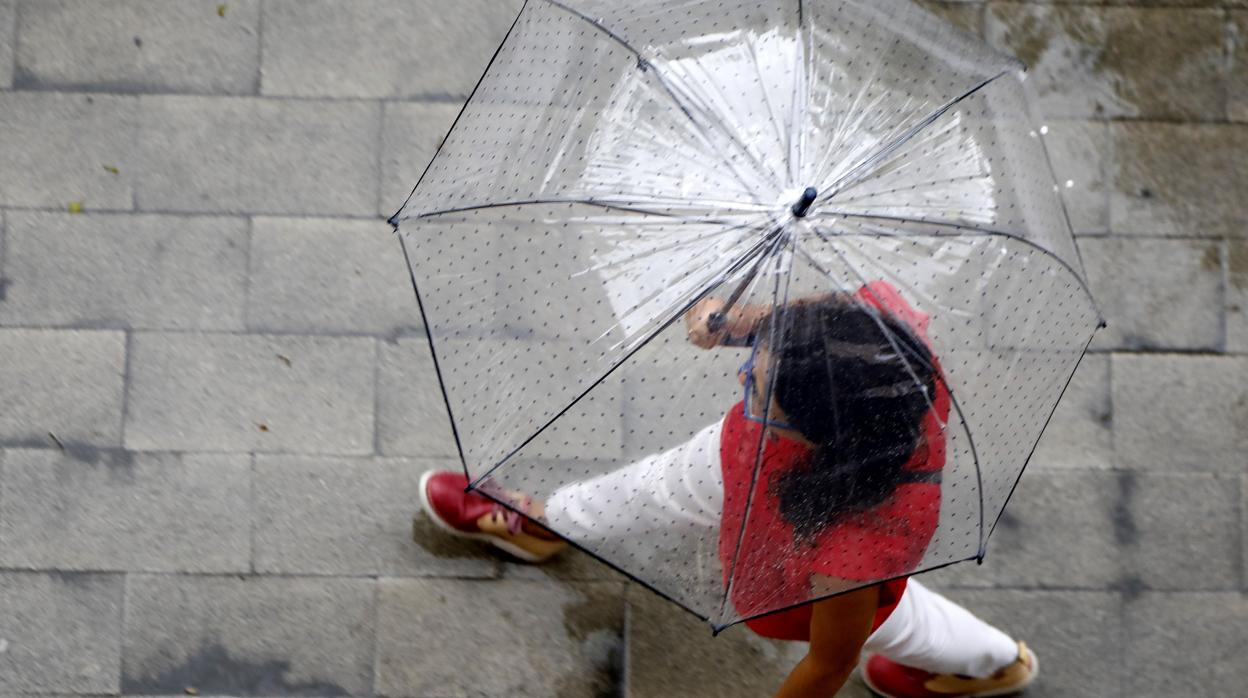 Imagen de una chica protegiéndose de la lluvia en Alicante