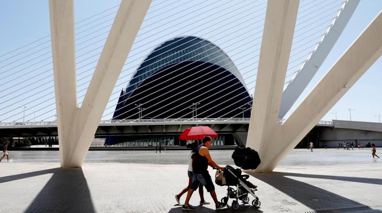 Una pareja se protege con paraguas del sol en el Ágora de la Ciudad de las Ciencias en Valencia, este fin de semana