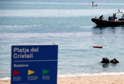 Imagen de los operativos de la Guardia Civil analizando la situación del artefacto encontrado en una playa de Badalona (Barcelona)