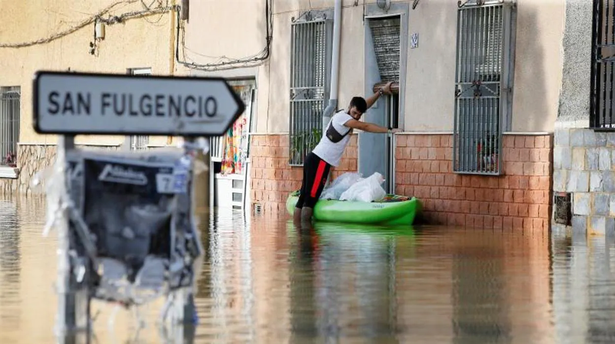 Un vecino de Dolores transporta objetos personales en una canoa al tener su casa inundada tras la DANA