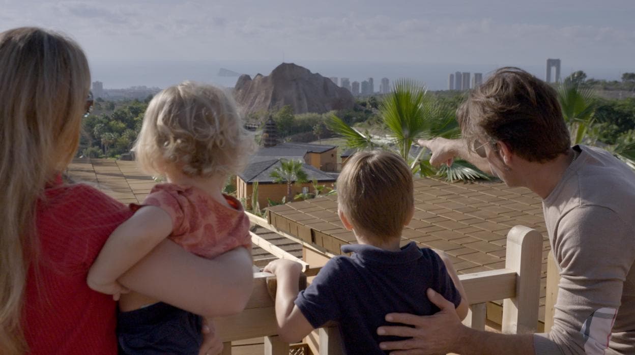 Una familia disfruta de las vistas a las zonas de animales en libertad desde una cabaña del resort