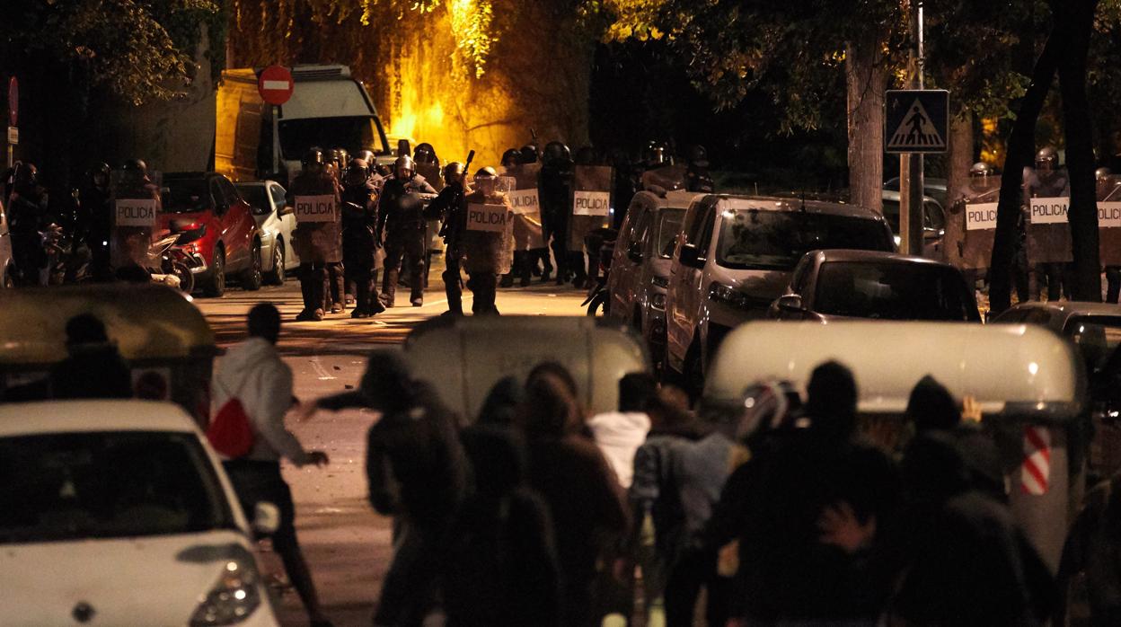 Los Mossos d'Esquadra se acercan a un grupo de manifestantes parapetados tras unos contenedores, el miércoles por la ncohe en Gerona