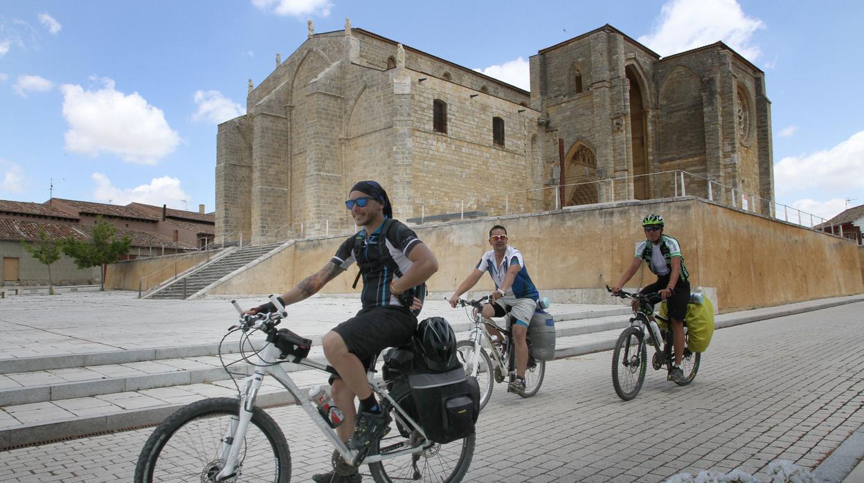 Peregrinos pasando frente a la Iglesia de Santa María la Blanca de Villasirga (Palencia)