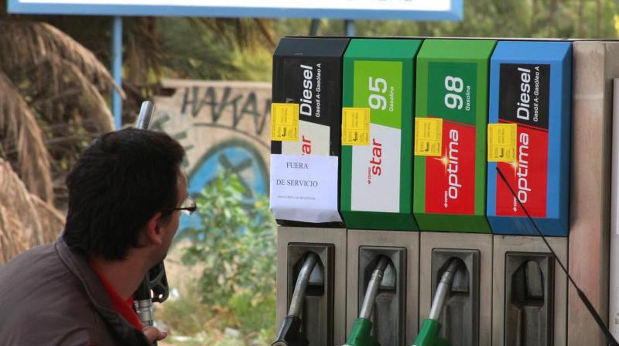 Un conductor observa los surtidores en una gasolinera de Alicante