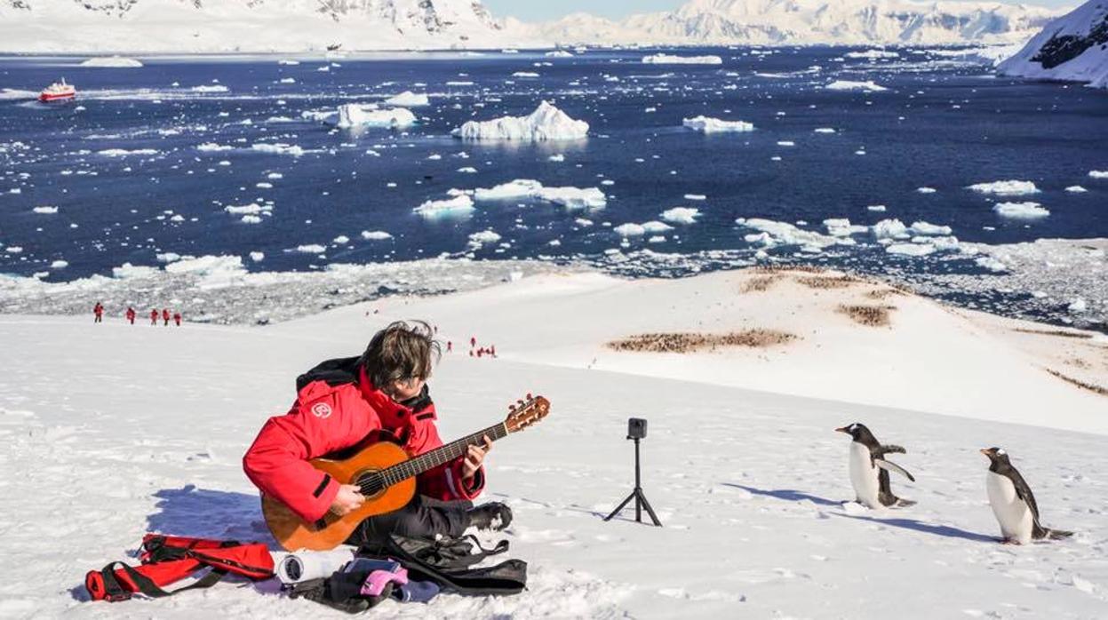 Rafael Serrallet tocando en la Antártida delante de pingüinos
