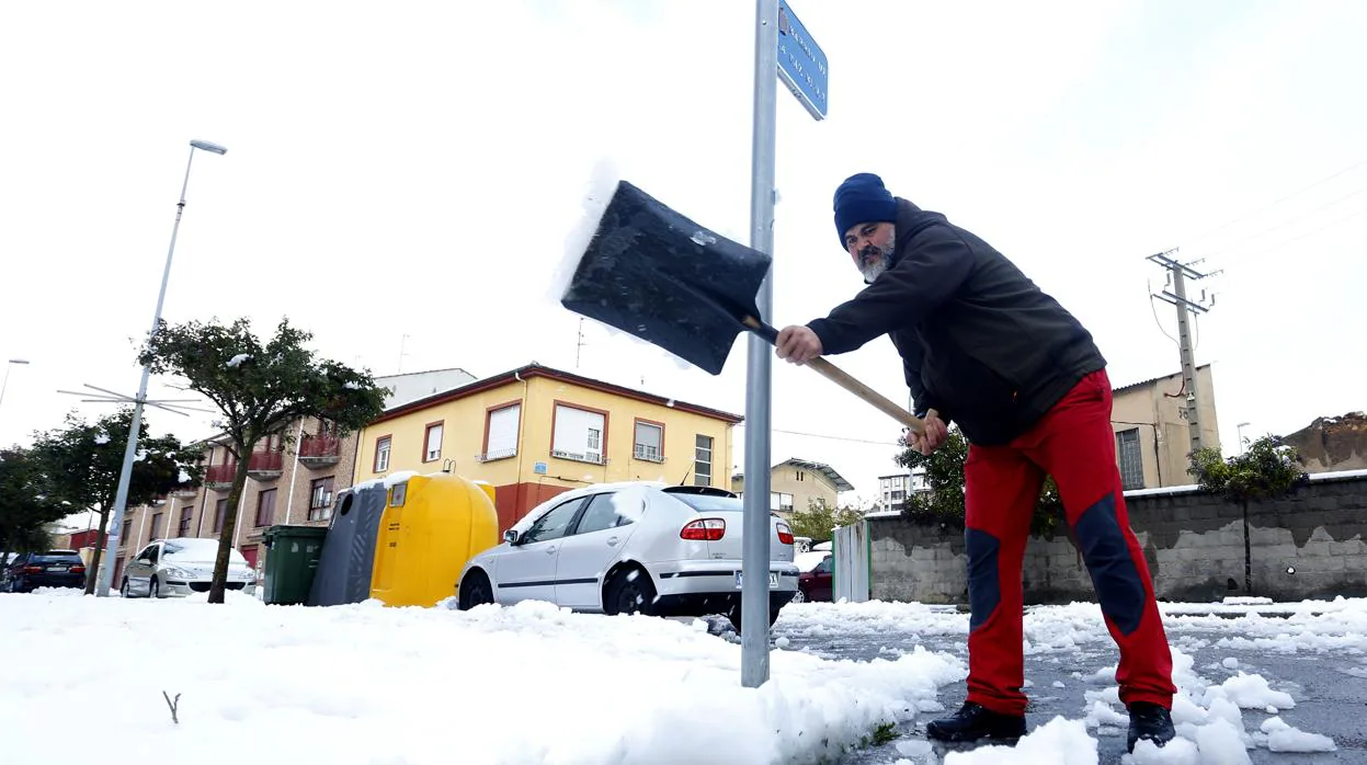 Un vecino de La Robla intenta limpiar la nieve de una de las vías del municipio