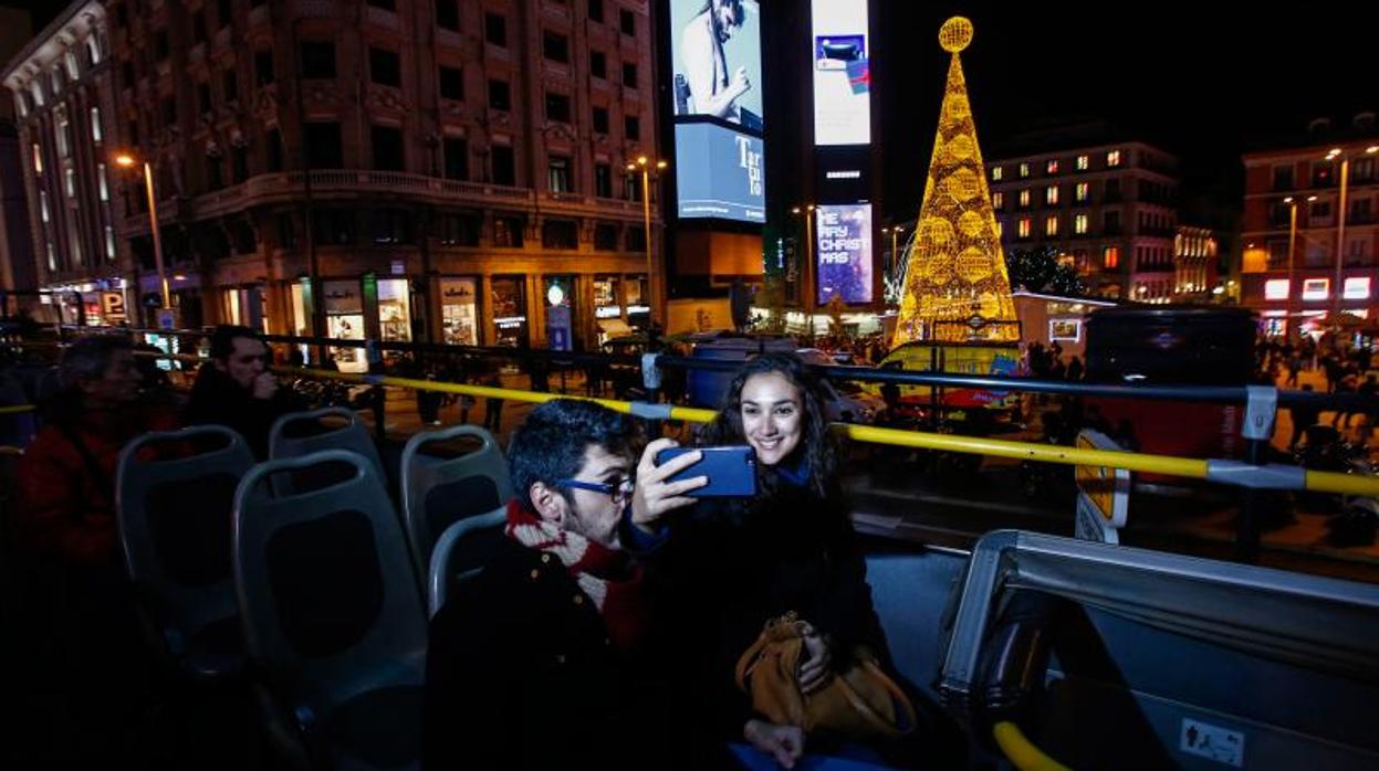 Varios usuarios del Naviluz se fotografían con las luces navideñas de fondo durante la edición del año pasado