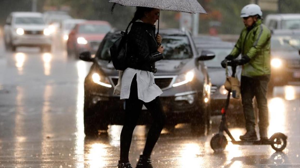 Transeúntes se desplazan bajo la lluvia este lunes en un municipio alicantino