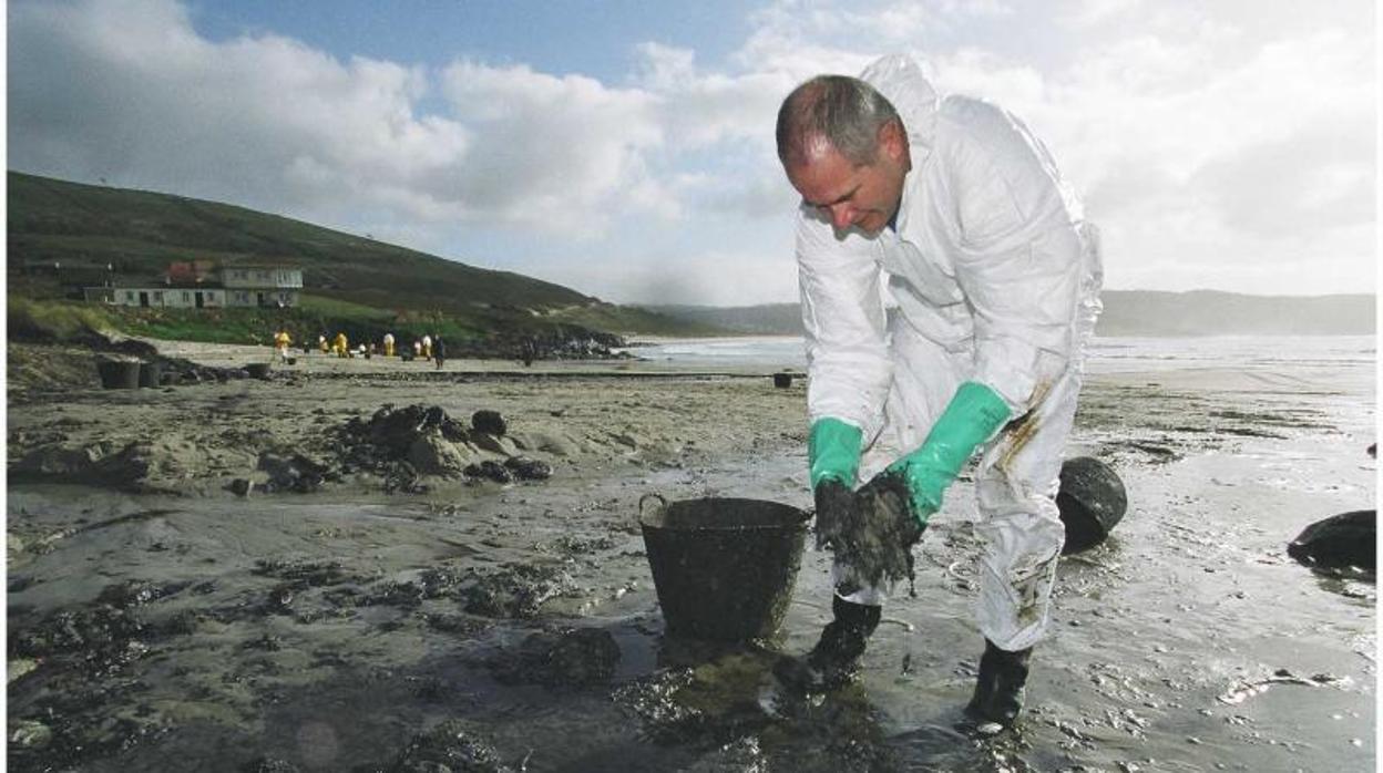 Un voluntario recogiendo chapapote en la playa de Nemiña, en la Costa da Morte