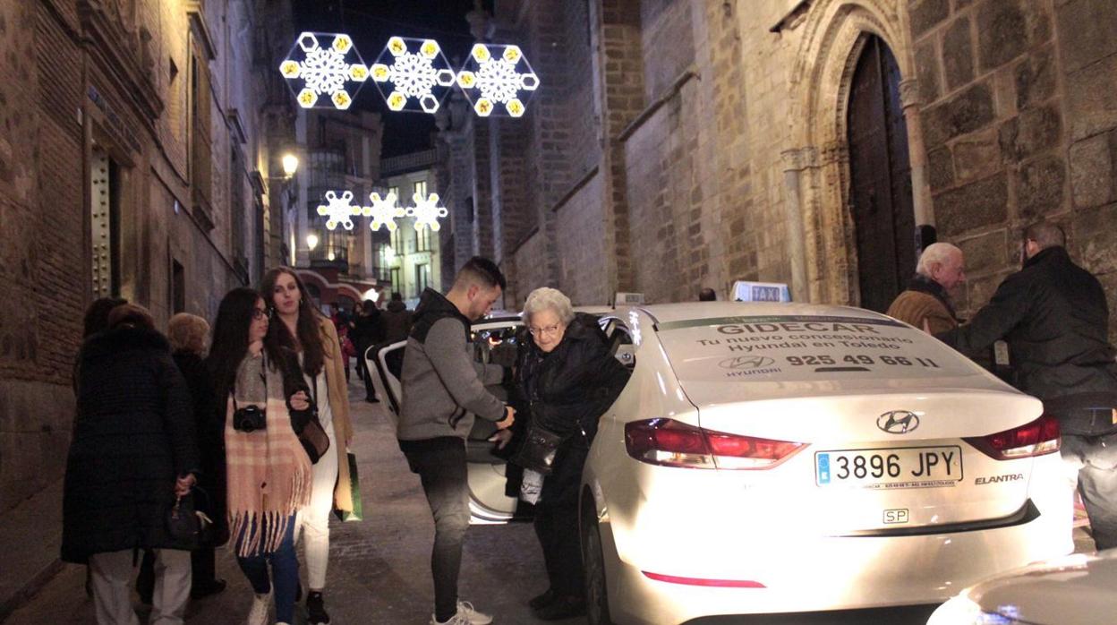 Taxistas de Toledo ayudando a bajar a personas mayores de un taxi