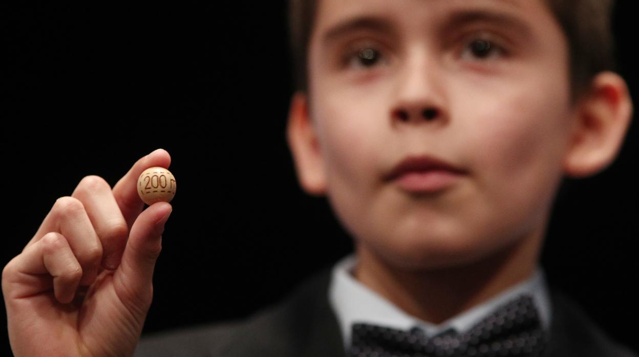 Un niño de San Ildefonso con la bola correspondiente a uno de los cuartos premios