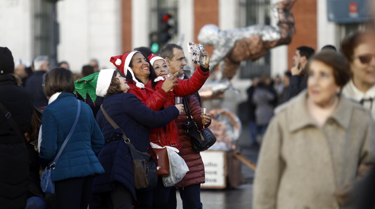 Varias personas celebran la Navidad en la Puerta del Sol