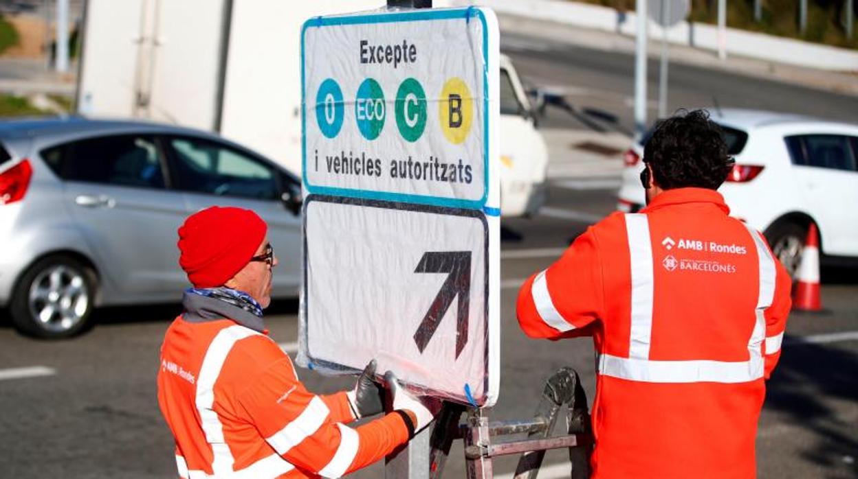 Operarios instalando carteles informativos sobre la nueva Zona de Bajas Emisiones que se estrena en 2020