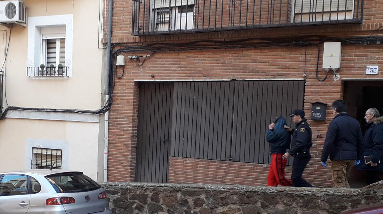 El detenido, con un chándal rojo, sale este domingo de su casa, el primer piso del número 37