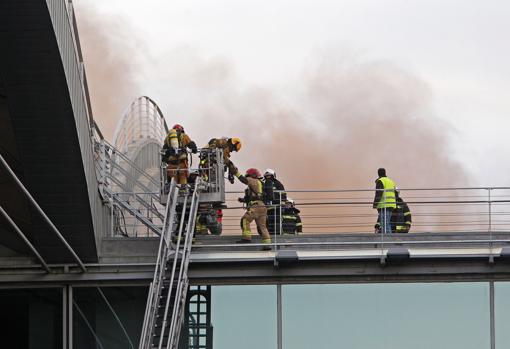 Imagen de los bomberos trabajando en la extinción del incendio en el aeropuerto de Alicante-Elche